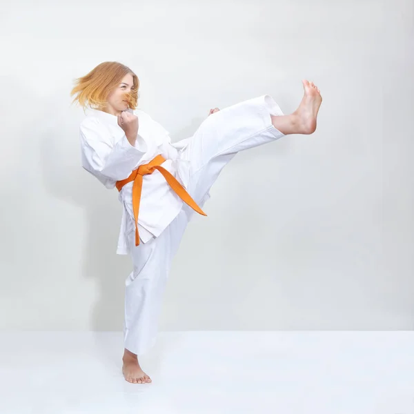 Ránu nohy holka je trénink s oranžovým pásem — Stock fotografie