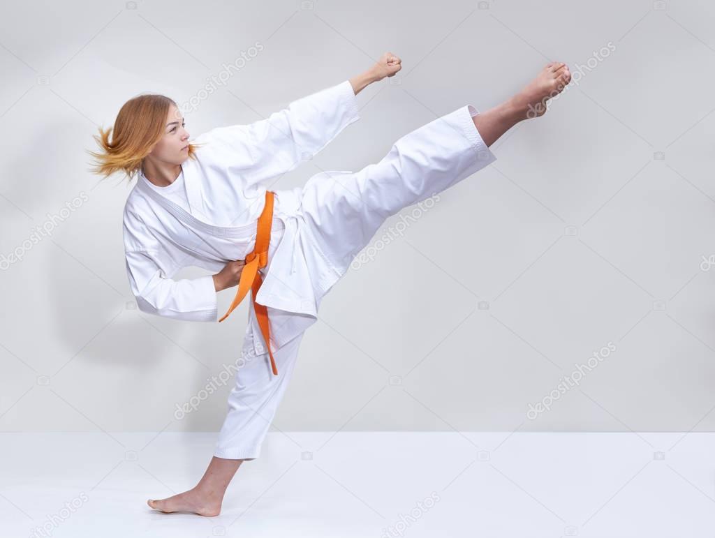 With an orange belt the girl beats a kick