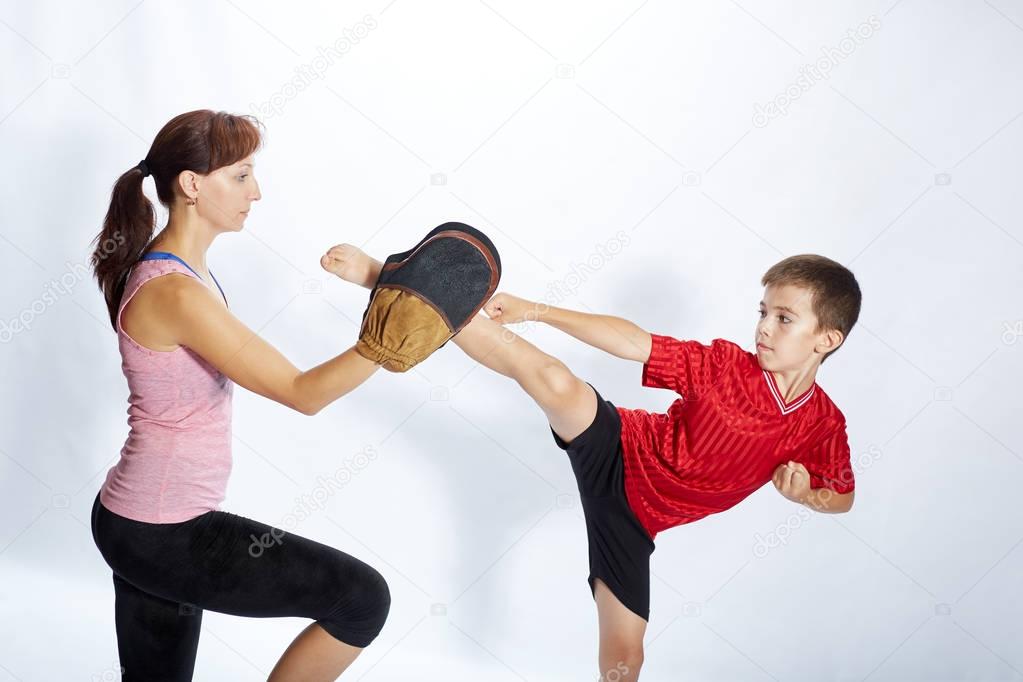 Boy is beating kick leg on the simulator that mom keeps