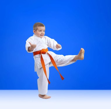 Mavi bir arka plan üzerinde küçük bir atlet tekme atıyor