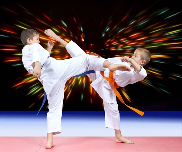 Zwei Jungen schlagen Tritte in den Hintergrund der hellen Strahlen — Stockfoto