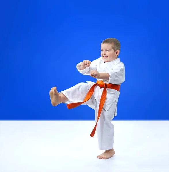 La jambe de coup est garçon d'entraînement dans karategi — Photo