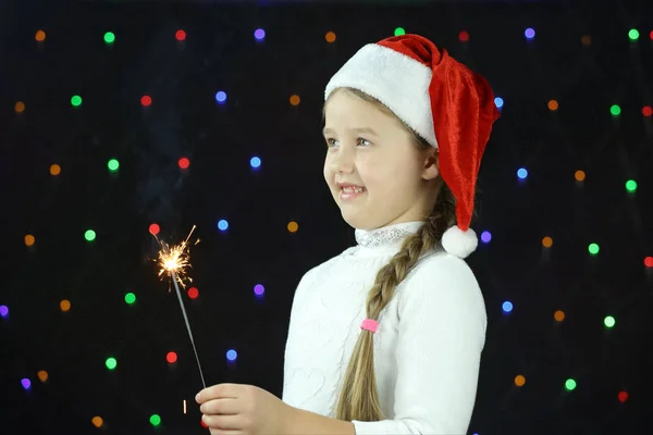 Ein Mädchen Mit Weihnachtsmann Hut Hält Ein Bengalfeuer Der Hand — Stockfoto