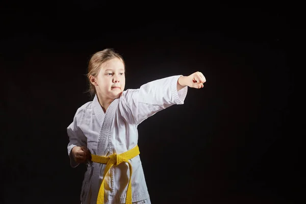 Karategi 的女孩在黑色的背景下训练一拳 — 图库照片