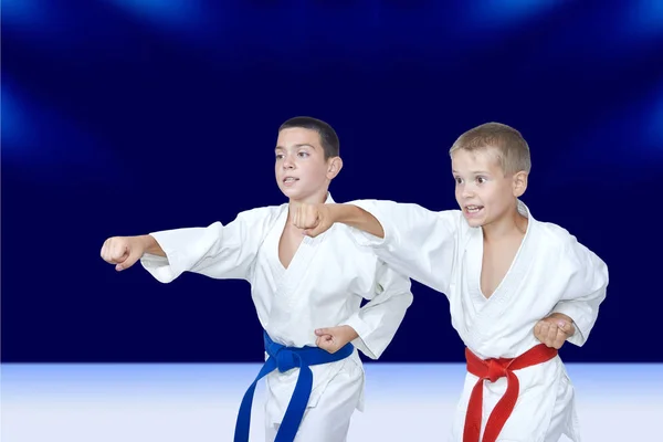 With red and blue belt athletes train punch arm