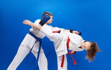 Çocuk karate darbeler mavi bir arka plan üzerinde eğitim
