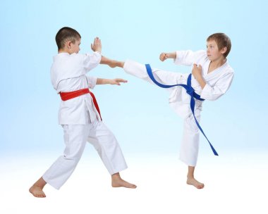 Hafif bir arka plan üzerinde sporcuların eğitim tekme ve blok