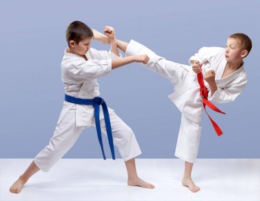 Gri bir arka plan üzerinde çocuklar darbeler kol ve bacak dövüyorsun