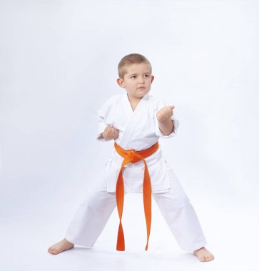 Karate rafında küçük bir atlet duruyor.