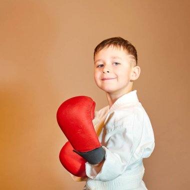 Koyu turuncu arka planda küçük bir sporcunun ellerinde kırmızı çizgiler vardı.