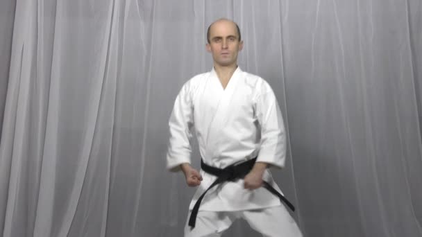 Athlete Trains Formal Karate Exercises Light Background — Stock Video