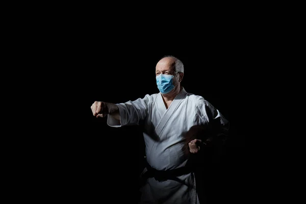 Viejo Atleta Una Máscara Médica Entrena Golpe Sobre Fondo Negro —  Fotos de Stock