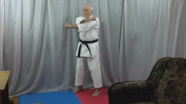 Karantinada kendini izole eden yaşlı bir erkek sporcu, bir dizi yumruğa hazırlanıyor.