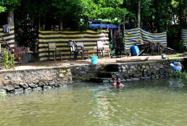 Durgun sularda yıkanan bir adam.