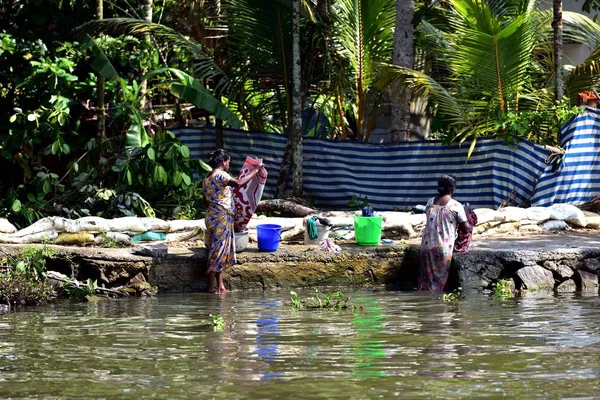 Dos damas lavando su ropa semanal en la orilla del río — Foto de Stock