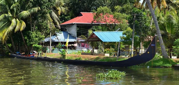 Bateau long traditionnel amarré le long de la maison — Photo