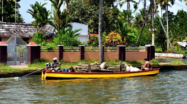 Barco amarillo lleno de troncos de árboles — Foto de Stock
