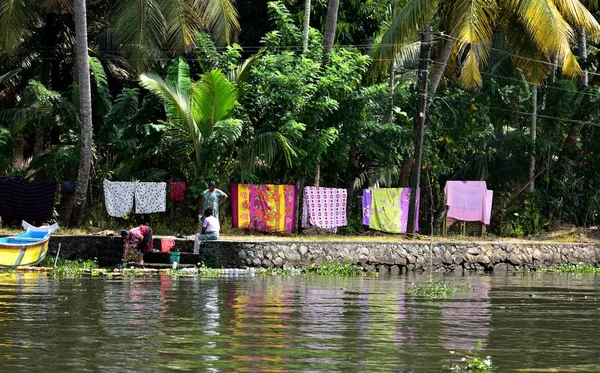 Un grupo de damas lavando su ropa semanal en la orilla del río — Foto de Stock