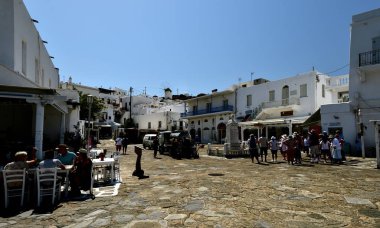 Mykonos kasabasını gezen turistler ve yerliler