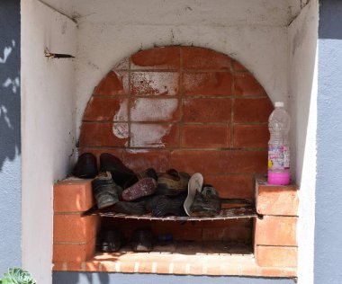 Furnas, Azores - 23rd April 2019:BBQ chimney with shoes on the grate