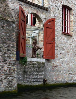 Bruges, Belgium - 29th April 19:Fun sculpture in a doorway on the canal side