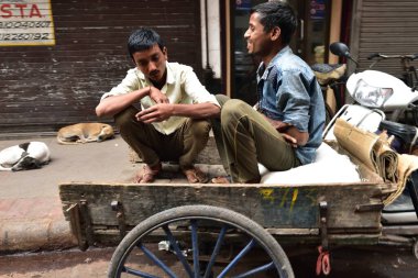 Eski Delhi, Hindistan - 7 Kasım 2019: Erkekler arabada otururken gülüyorlar