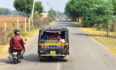 Agra, Hindistan - 8 Kasım 2019: Yerel halk Tuk Tukk 'un sırtından karşıya geçiyor