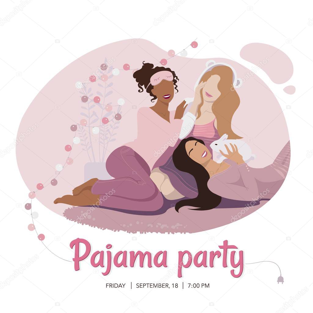 Three happy girls of diverse race in pink nightwear sitting on the carpet and playing with rabbit. Pajama party.