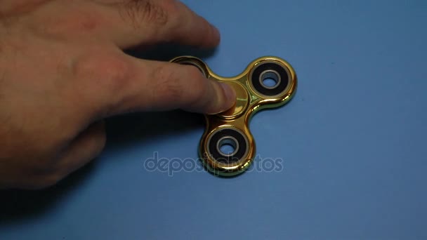 Gold spinner rotate on the blue background. Anti-stress. — Stock Video