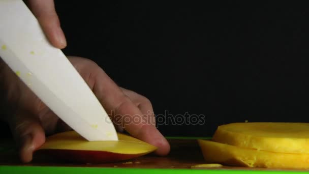Hände schneiden Mango auf schwarzem Hintergrund — Stockvideo