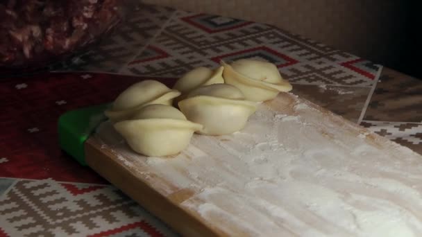 Une femme façonne la pâte avec de la viande à l'intérieur pour faire des boulettes . — Video