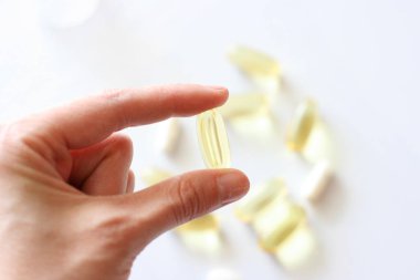 Kadınların eli bir hap tutuyor. Tabletler ve haplar masanın üzerinde. Farmakoloji geçmişi. Medicament bileşimi.