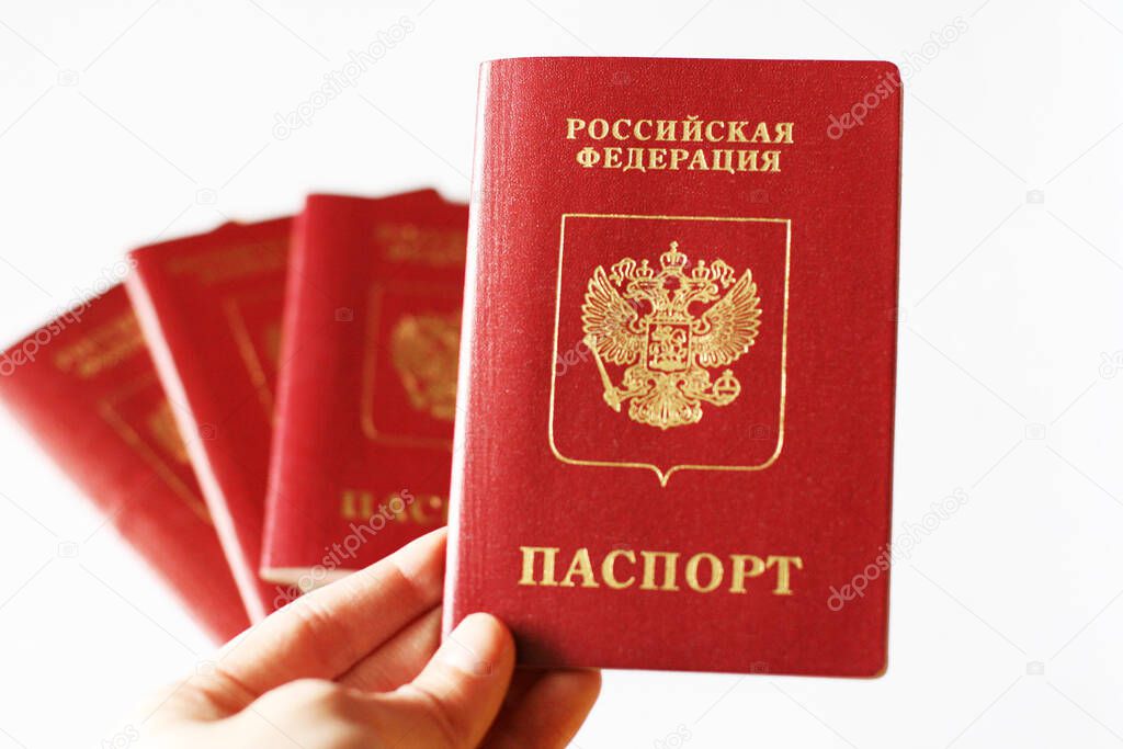 Woman s hand holding Russian passport. Red russian international passport in a hand on a white background