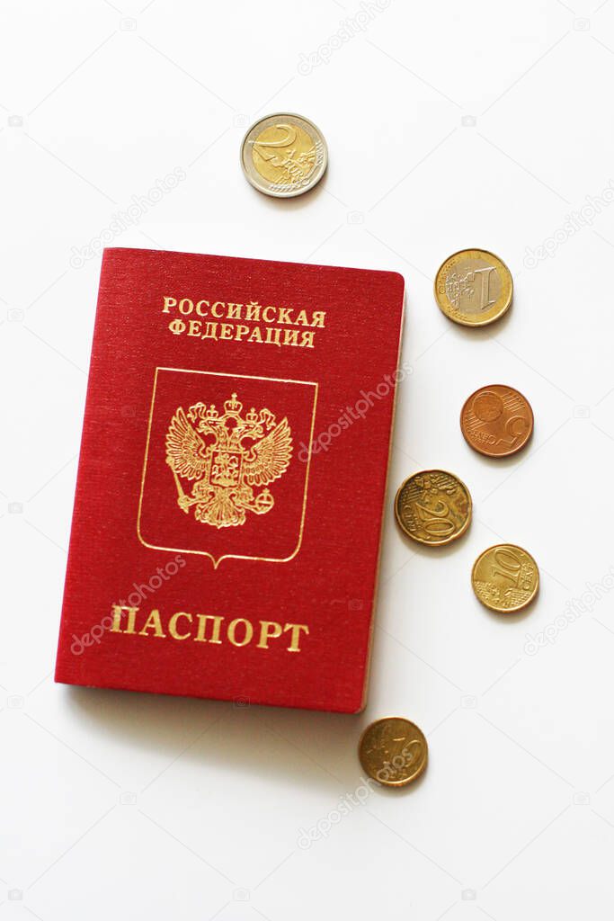 Russian foreign passport with euro coins on a white  background. Dark red passport cover with copy space
