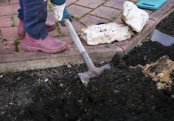 Bahçede toprak kazan biri. Tarım kutsaldır. Sallanma ya da düşme için bahçe hazırlığı