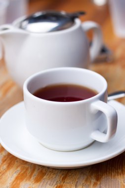 Beyaz fincan çay ve bir pot ahşap masa üzerinde yakın çekim