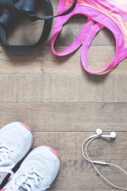 Düz yatıyordu boş defter, pembe spor sutyen, ahşap arka plan üzerinde cep telefonu