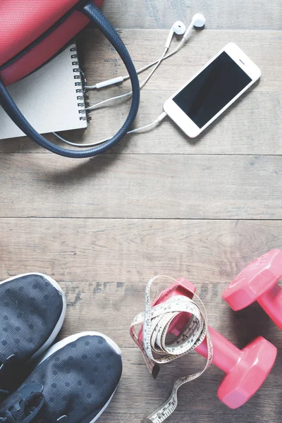 Flat lay de celular e equipamentos esportivos em fundo de madeira . — Fotografia de Stock