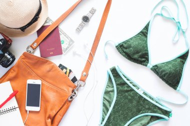 Yaz tatil öğeler kümesi. Yeşil renk bikini ile cep telefonu, deri çanta, kamera ve pasaport beyaz zemin üzerine yaz tatili için