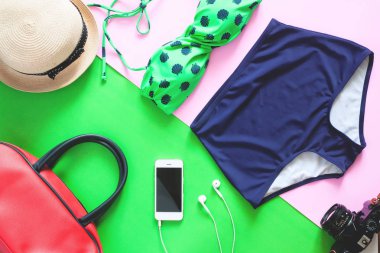 Düz yaz öğeleri kümesi yatıyordu. Yeşil renk bikini ile cep telefonu ve yaz tatili yeşil ve pembe arka plan öğeleri