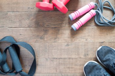 Düz kırmızı dumbell ve Spor donatımı ahşap zemin üzerinde yatıyordu