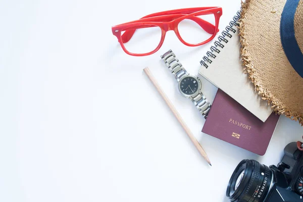 Travel items, passport, camera, notebook, watch and hat on white