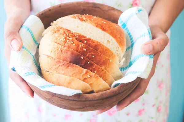 Frau serviert Laib Brot in Holzschüssel — Stockfoto