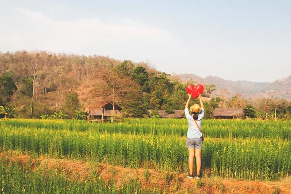 Joven viajero en momento de felicidad de pie en el campo de flores amarillas — Foto de Stock