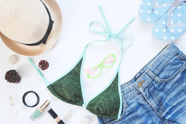 Vrouwelijke zomercollectie met bikini, korte jeans, accessoires en cosmetica geïsoleerd op een witte achtergrond, bovenaanzicht — Stockfoto