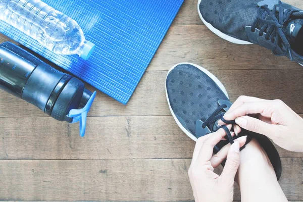 Mão feminina ativa com esporte e equipamentos de trabalho, flat lay no chão de madeira — Fotografia de Stock