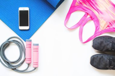 Beyaz arka plan üzerinde yoga ve spor aletleri ile Smartphone havai görünümü