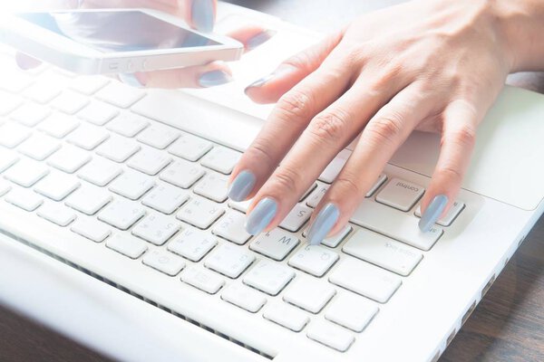 Онлайн маркетинговая концепция с женской рукой с помощью мобильного устройства и лапроп-компьютера
