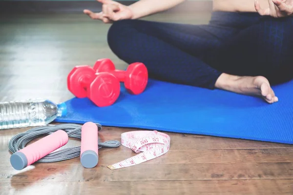 Sport- und Yogageräte mit Maßband und asiatischem Frauen-Yoga zu Hause, gesunder Lebensstil mit selektivem Fokus — Stockfoto