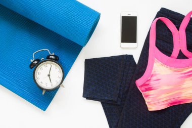 Çalar saat ve smartphone ile yoga ekipmanları w üzerinde düz lay